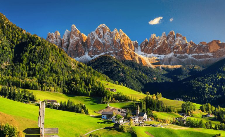 Dolomitas de fondo con un prado verde, cielo azul y un sendero - centre europeu